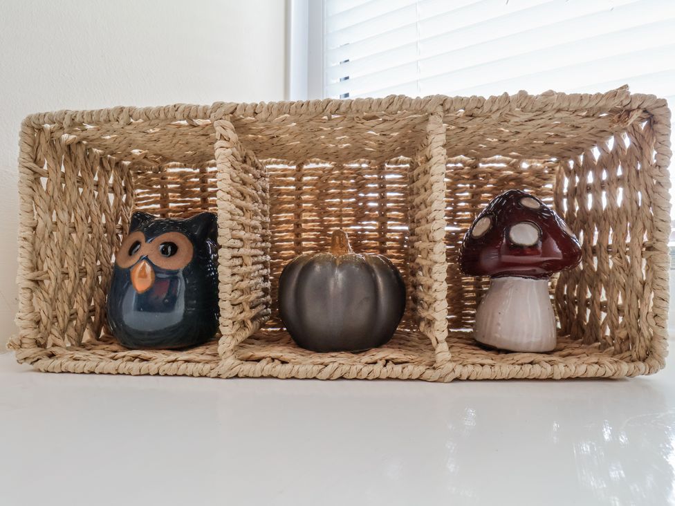 A decorative basket with an owl, pumpkin, and mushroom figurines at Starlight Cottage