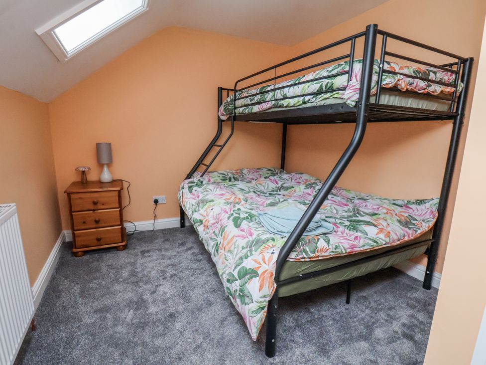 A bedroom with bunk bed and nightstand at Starlight Cottage