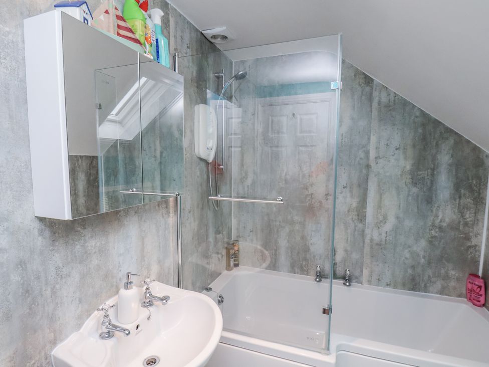 A bathroom with a washbasin and shower at Starlight Cottage