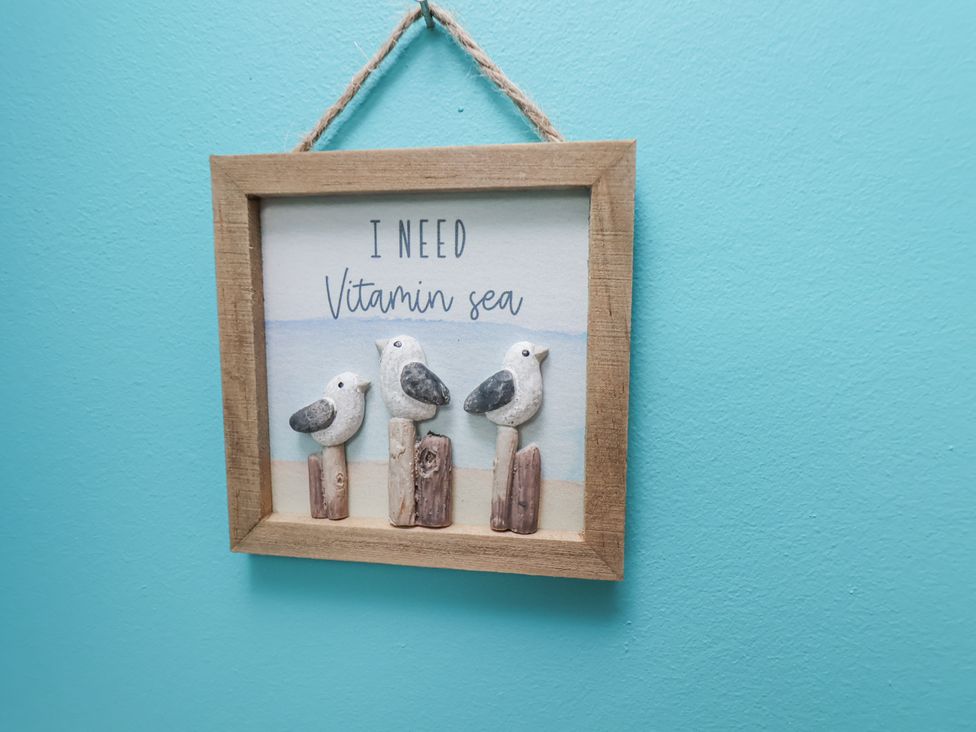 A framed picture with decorative birds and text at Starlight Cottage