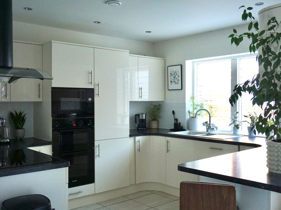 A kitchen with cabinets, oven, microwave and plants at the property.