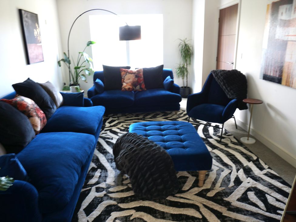 A living room with blue furniture and a zebra print rug at the property