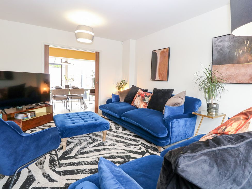 A living room with a blue sofa and television at Manor Park View in Norwich