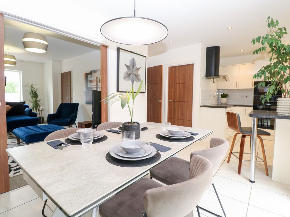 A dining room with a table and chairs at Manor Park View in Norwich