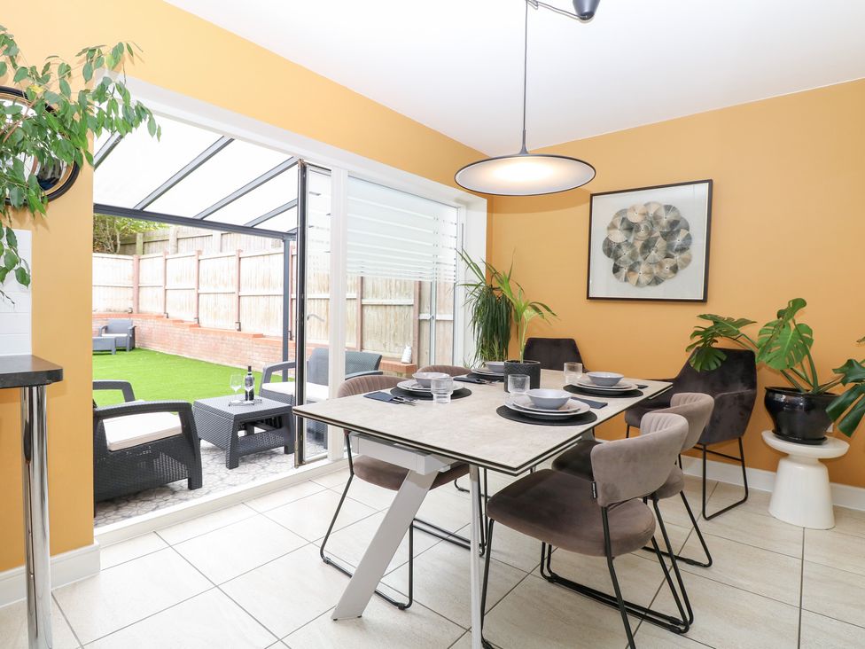 A dining room with a table and chairs at Manor Park View in Norwich