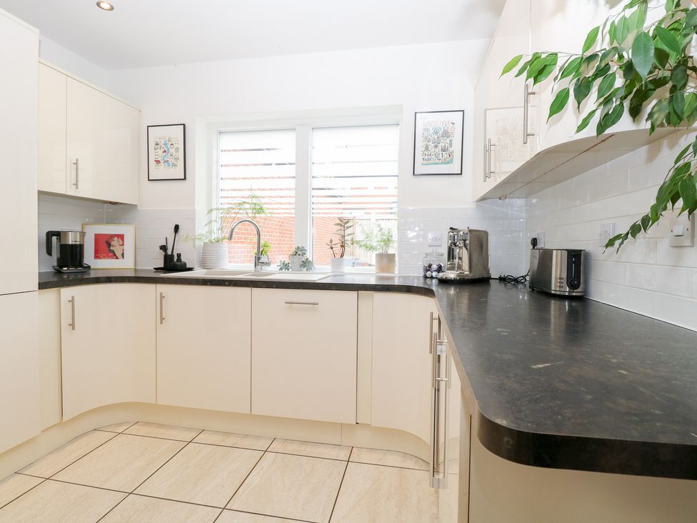 A kitchen with cabinets, sink and coffee maker at Manor Park View Norwich