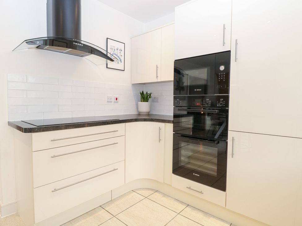 A kitchen with cabinets, an oven, and an extractor hood at Manor Park View, Norwich