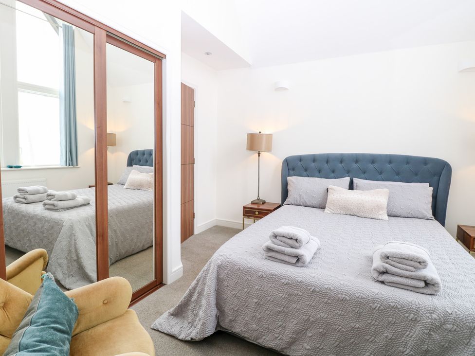 A bedroom with a bed and a mirror at Manor Park View in Norwich