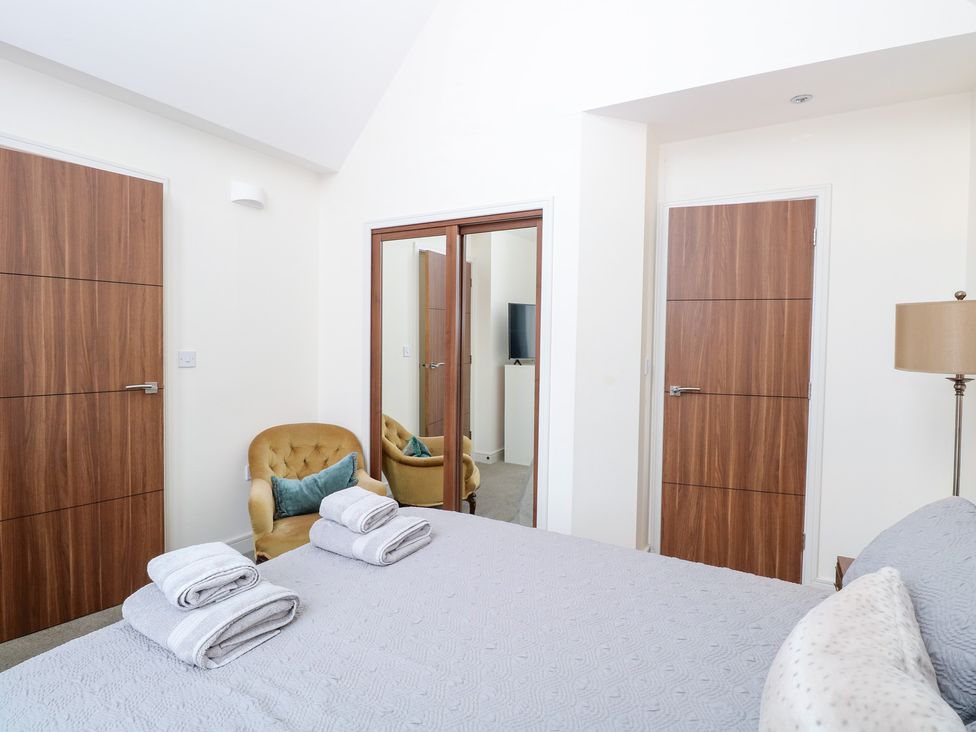 A bedroom with a bed and armchair at Manor Park View in Norwich