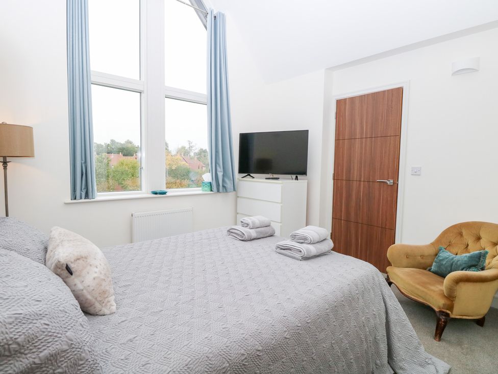 A bedroom with a bed and television at Manor Park View in Norwich