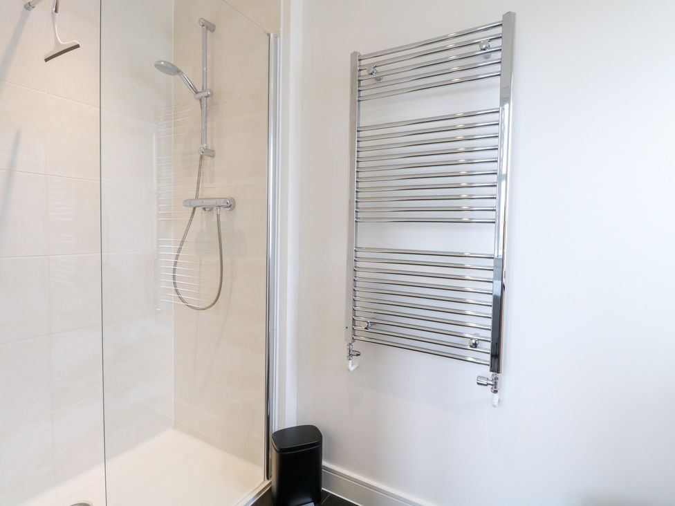 A bathroom with a shower and towel rail at Manor Park View in Norwich