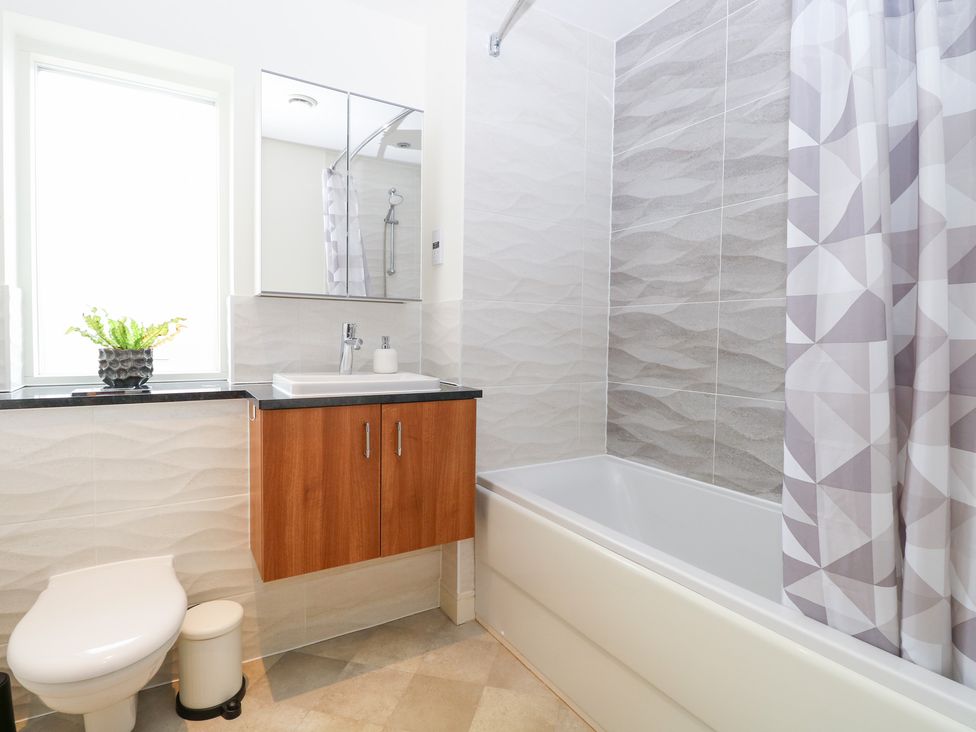 A bathroom with a bathtub, sink, and toilet at Manor Park View in Norwich