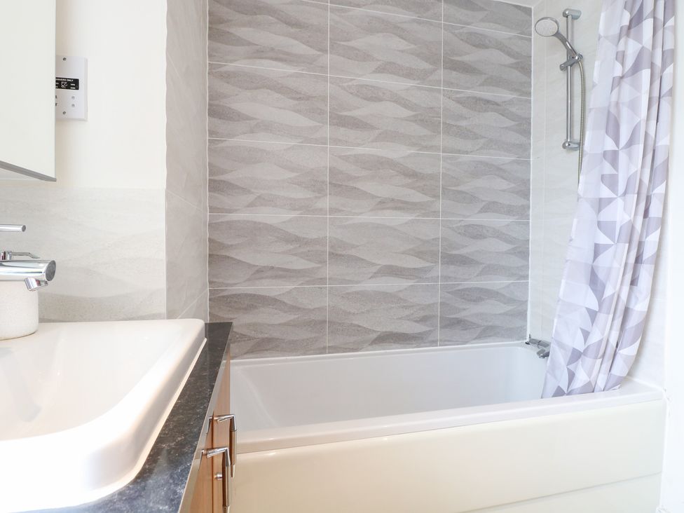A bathroom with a bathtub and showerhead at Manor Park View in Norwich