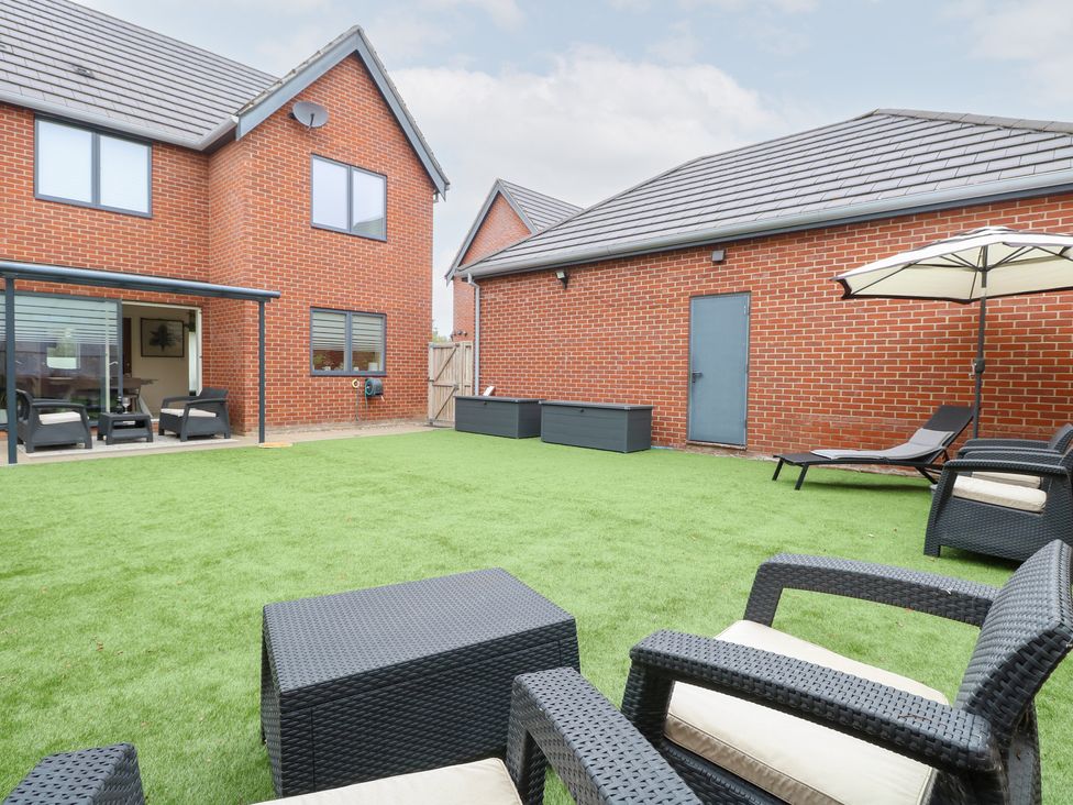 A garden with seating and lawn at Manor Park View in Norwich
