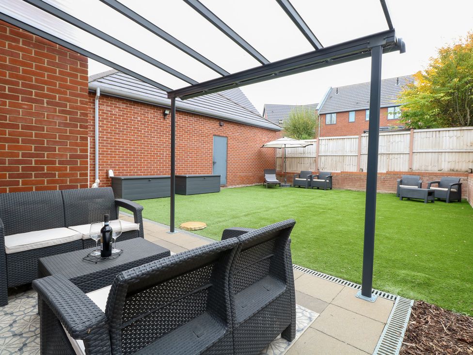 A garden with seating area and a lawn at Manor Park View in Norwich