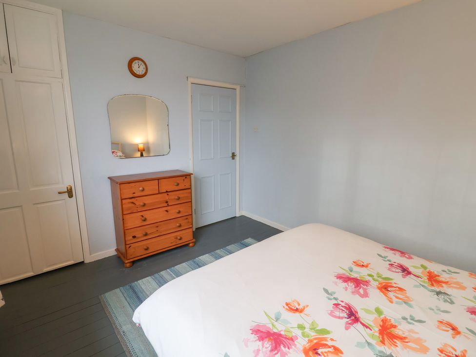 A bedroom with a bed and a wooden dresser at Cromer Holiday Home in Cromer