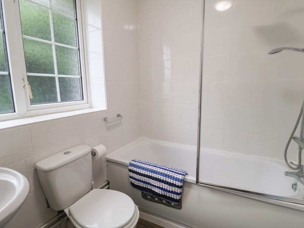 A bathroom with a bath, toilet, and sink at Cromer Holiday Home in Cromer