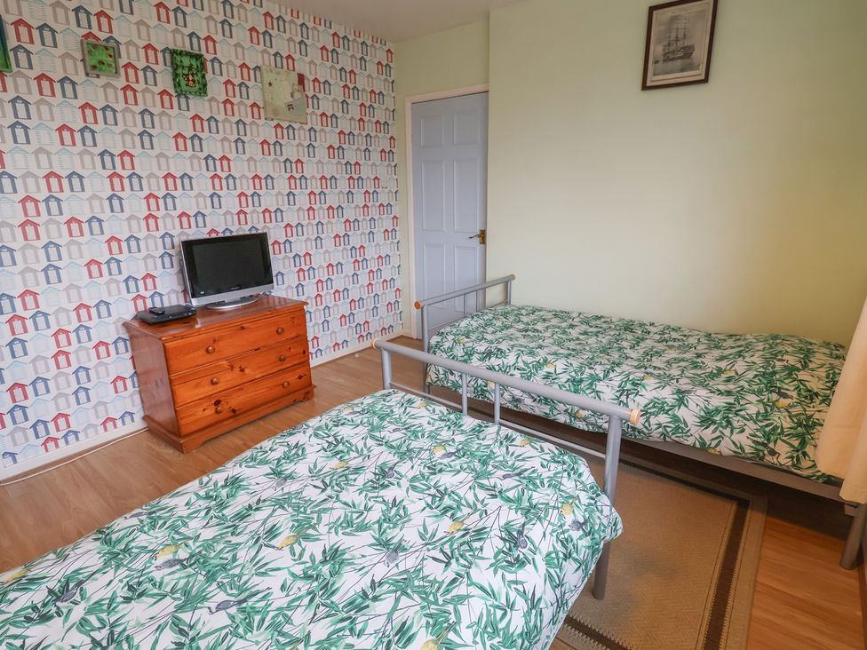 A bedroom with two beds and a television at Cromer Holiday Home in Cromer
