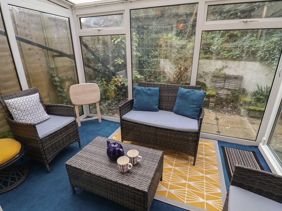 A conservatory with wicker furniture and a coffee table at Cromer Holiday Home in Cromer