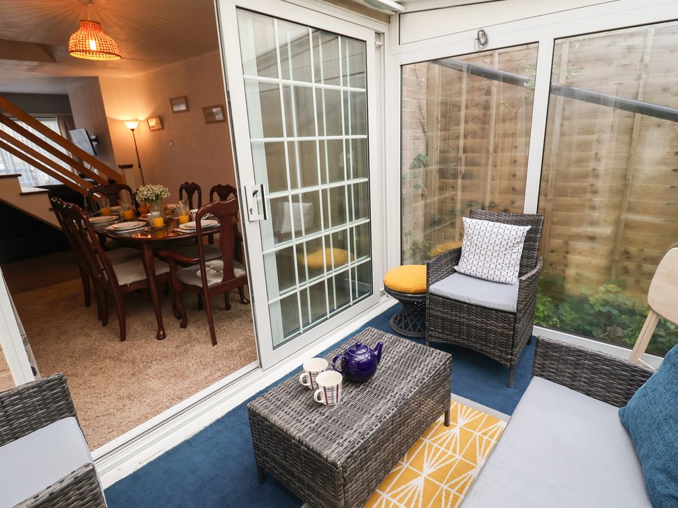 A conservatory with a seating area and a dining table at Cromer Holiday Home in Cromer
