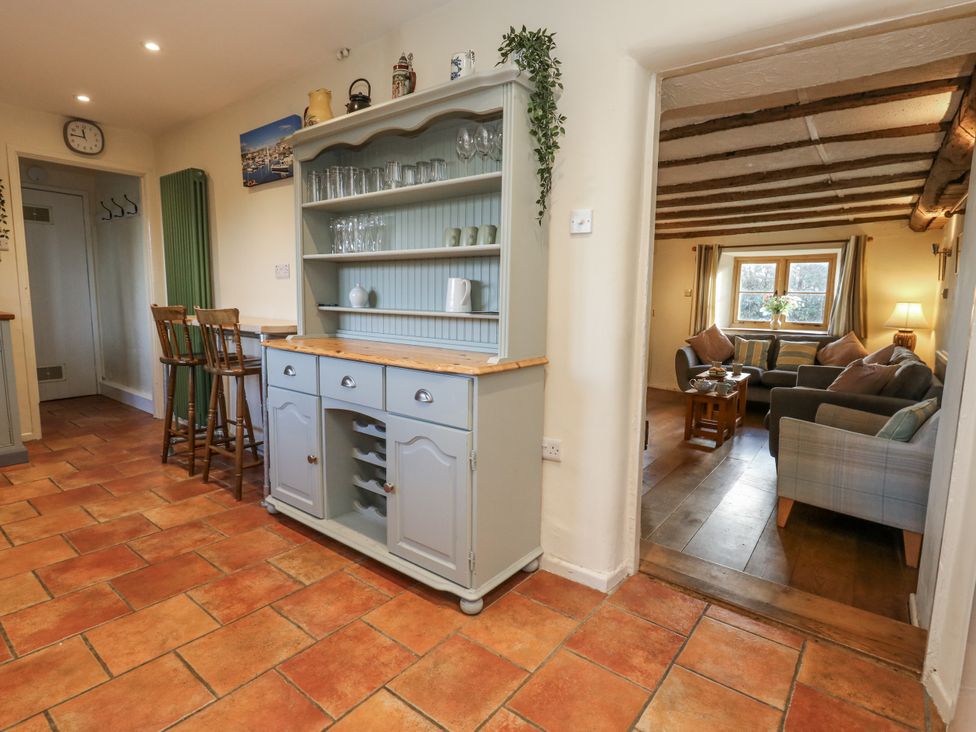 A kitchen with a counter and bar stools at Honeysuckle Cottage Smallridge Nr. Axminster