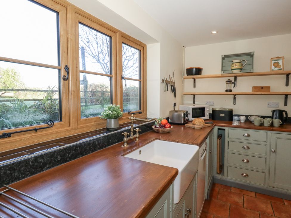 A kitchen with wooden countertops and a sink at Honeysuckle Cottage in Smallridge Nr. Axminster