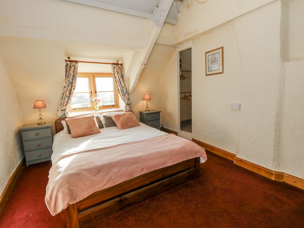A bedroom with a bed and two nightstands at Honeysuckle Cottage in Smallridge Nr. Axminster