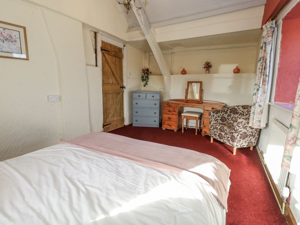 A bedroom with a bed, wardrobe, and dresser at Honeysuckle Cottage in Smallridge Nr. Axminster