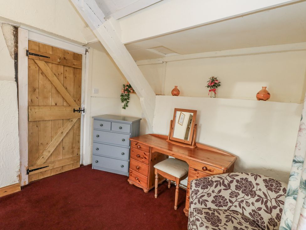 A bedroom with a dresser and chair at Honeysuckle Cottage Smallridge Nr. Axminster