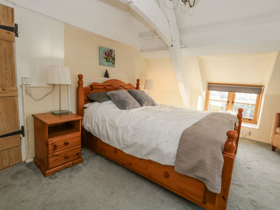 A bedroom with a bed and bedside table at Honeysuckle Cottage in Smallridge Nr. Axminster