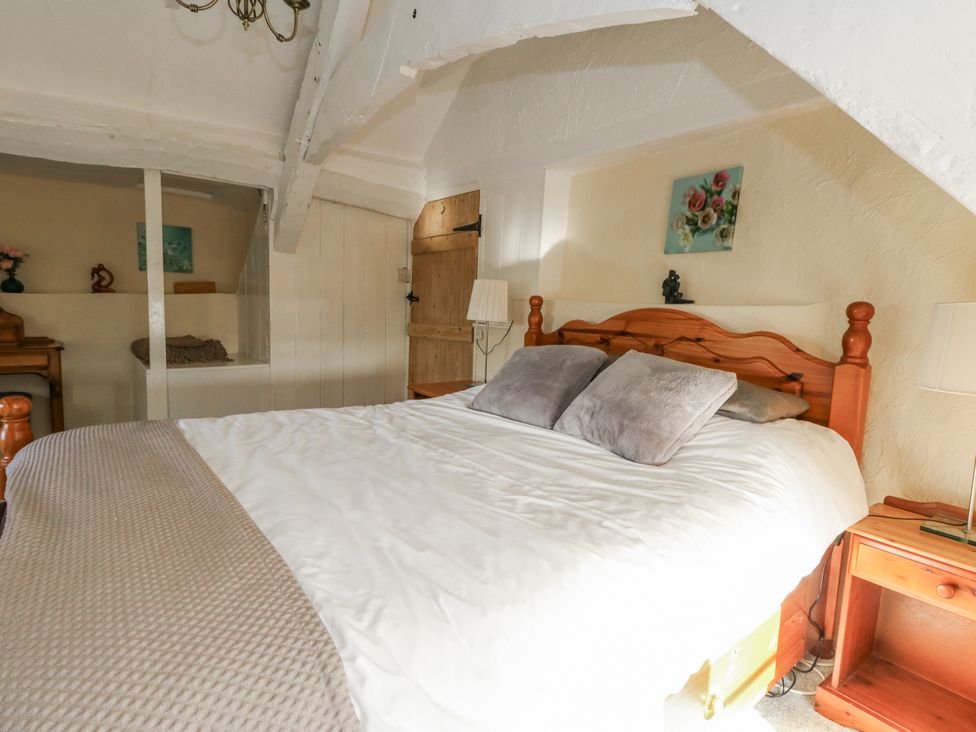 A bedroom with a bed and wooden furnishings at Honeysuckle Cottage in Smallridge Nr. Axminster