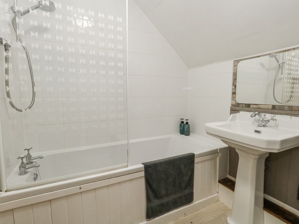 A bathroom featuring a bathtub and sink at Honeysuckle Cottage in Smallridge Nr. Axminster
