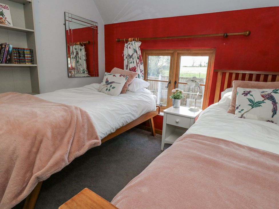 A bedroom with two beds and a nightstand at Honeysuckle Cottage Smallridge Nr. Axminster