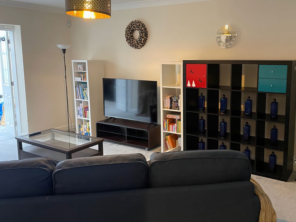 A living room with a television and bookshelves at 1 Oldridge Crescent Stockport