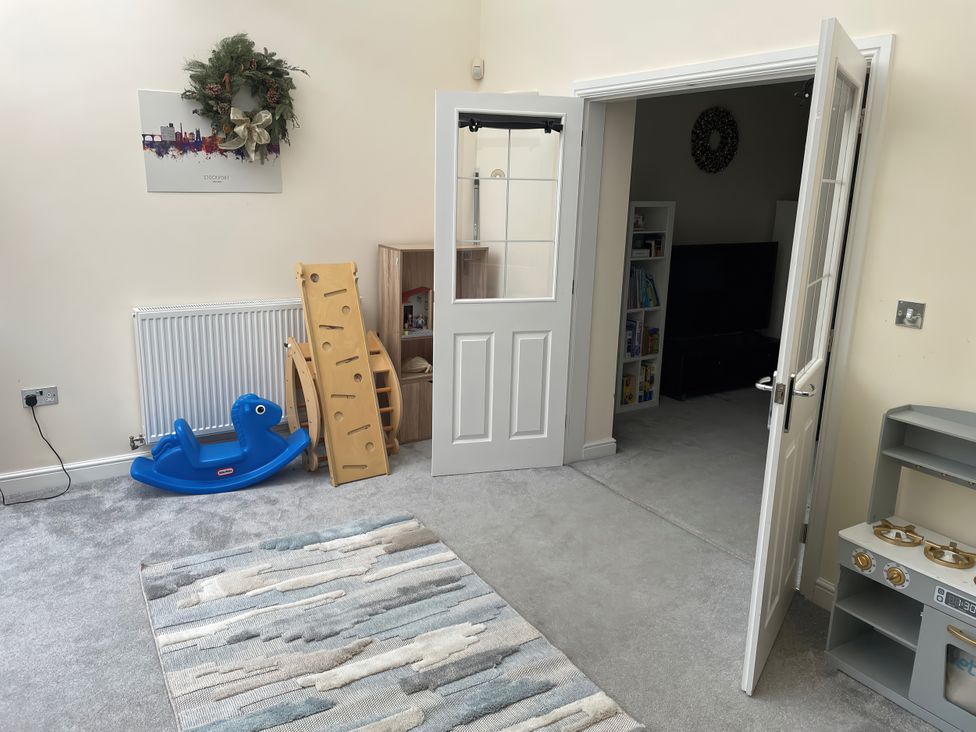 A playroom with a rocking toy and a shelf unit at 1 Oldridge Crescent in Stockport