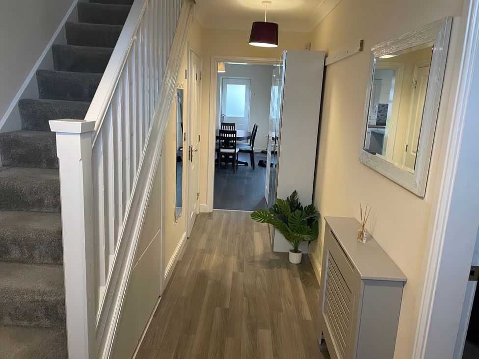 A hallway with a staircase and a plant at 1 Oldridge Crescent Stockport