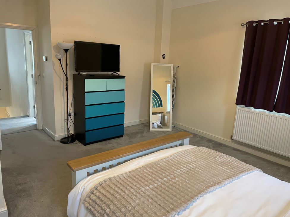 A bedroom with a television and dresser at 1 Oldridge Crescent in Stockport