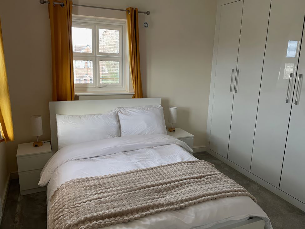 A bedroom with a bed and wardrobe at 1 Oldridge Crescent in Stockport