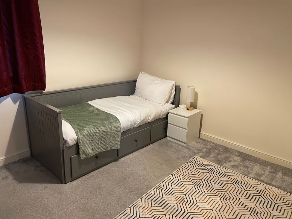 A bedroom with a bed and bedside table at 1 Oldridge Crescent in Stockport