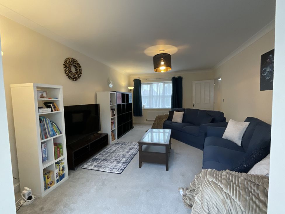 A living room with a sofa, coffee table, and bookshelf at The Winster in Marple, Stockport