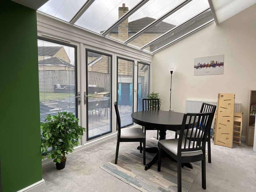 A dining table with chairs in a conservatory at The Winster in Marple, Stockport