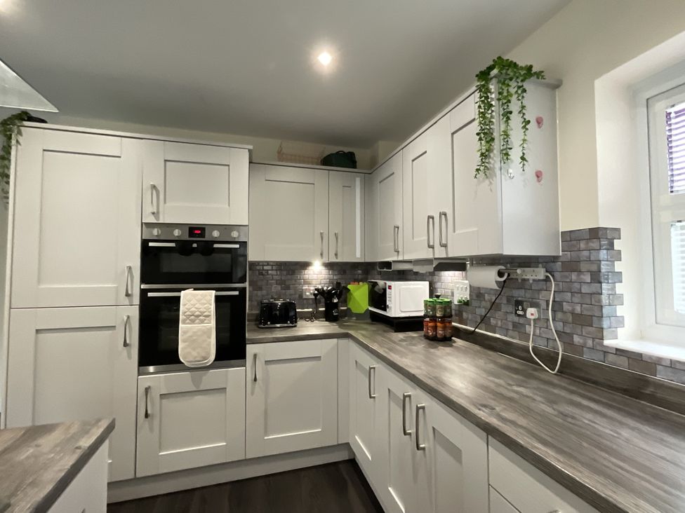 A kitchen with cabinets and appliances at The Winster in Marple, Stockport