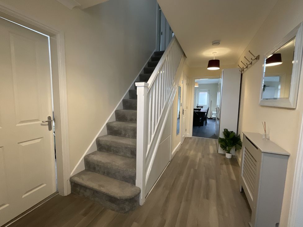 A hallway with stairs and a mirror at The Winster in Marple, Stockport