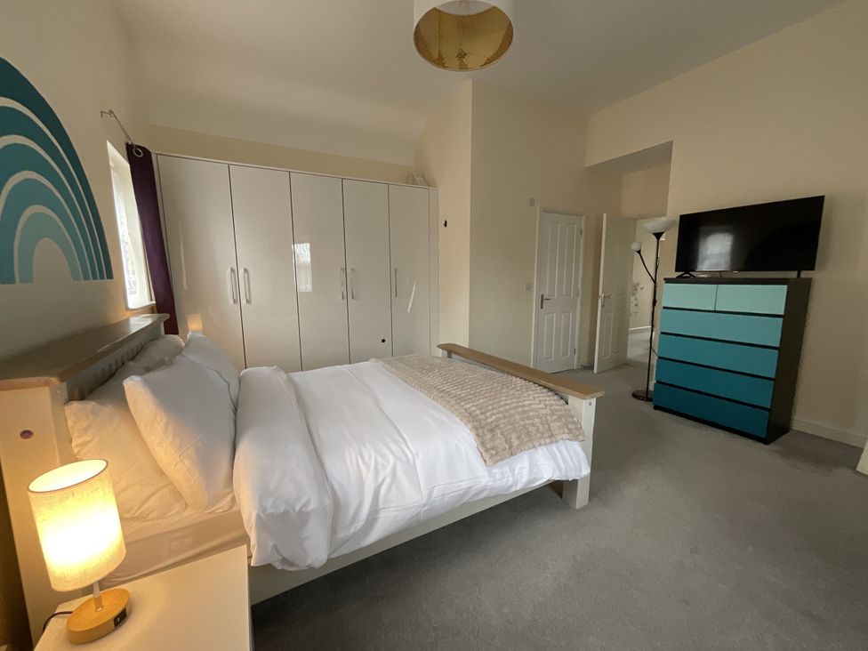 A bedroom with a bed and wardrobe at The Winster in Marple, Stockport