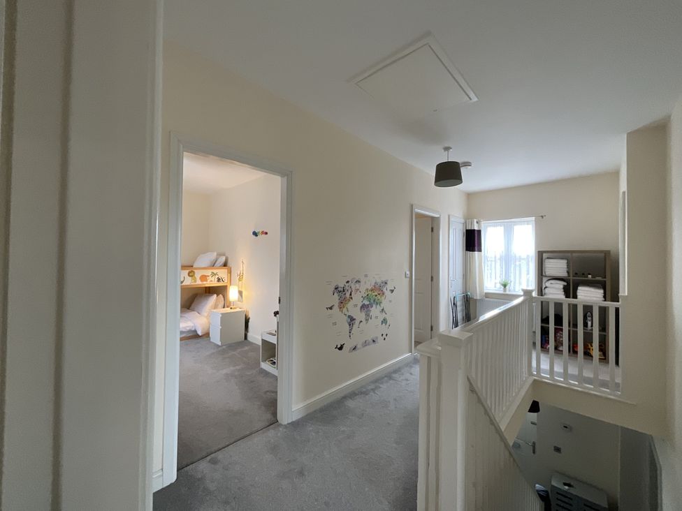 A hallway with doors and children's room entry at The Winster in Marple, Stockport