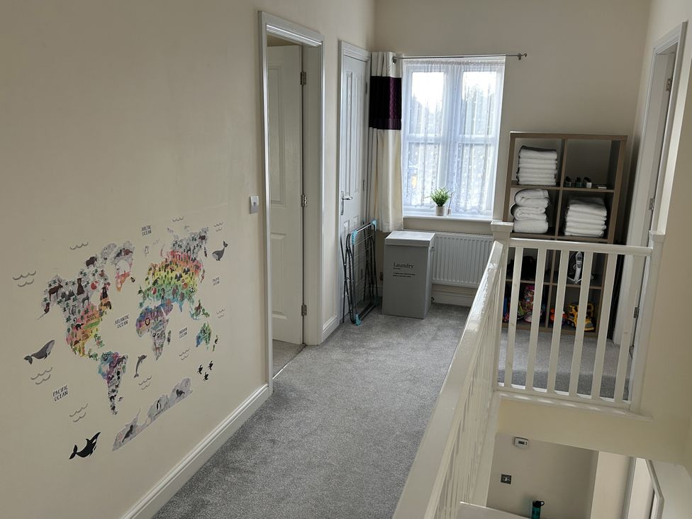 A hallway with a world map on the wall at The Winster in Marple, Stockport