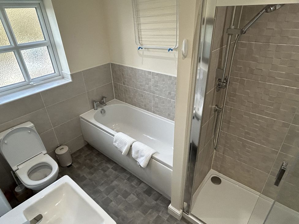 A bathroom featuring a bath tub, shower, toilet, and sink at The Winster in Marple, Stockport