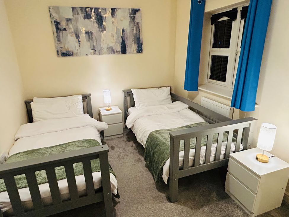 A bedroom with two single beds and a nightstand at The Winster in Marple, Stockport