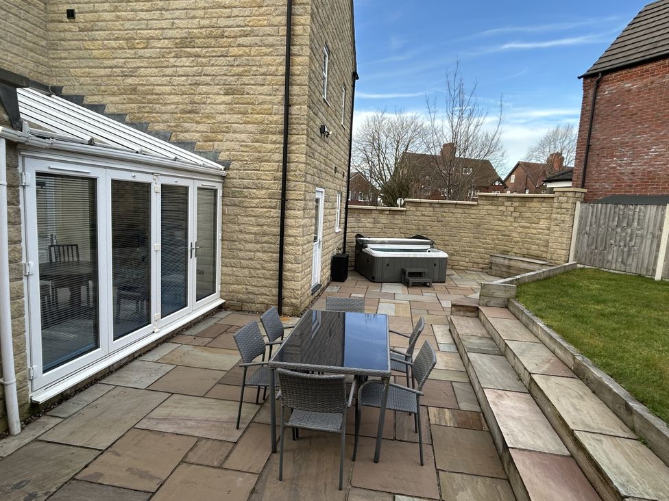 A garden with a table and chairs alongside a hot tub at The Winster in Marple, Stockport