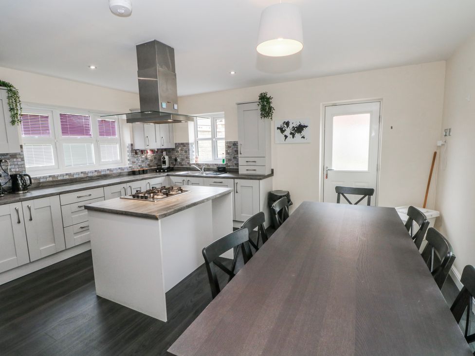 A kitchen with an island and dining table at The Winster in Marple, Stockport